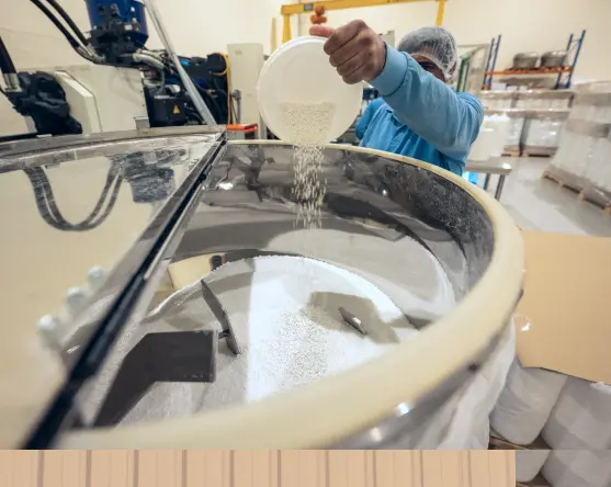Person pouring plastic granules into a machine